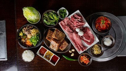 Top view Korean Grilled BBQ combo with marinated beef meat set on the traditional grill table, with...