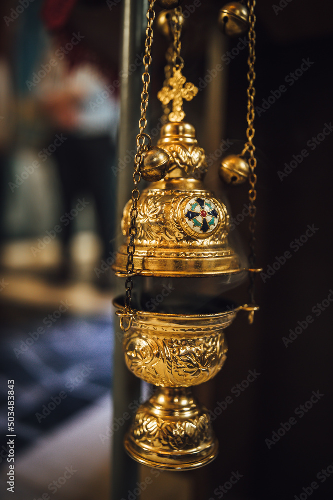 Sticker closeup of a censer hanging in a church