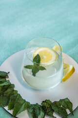 Tasty and healthy lemonade. Refreshing and energizing drink made with lemon and mint placed on a green background.
