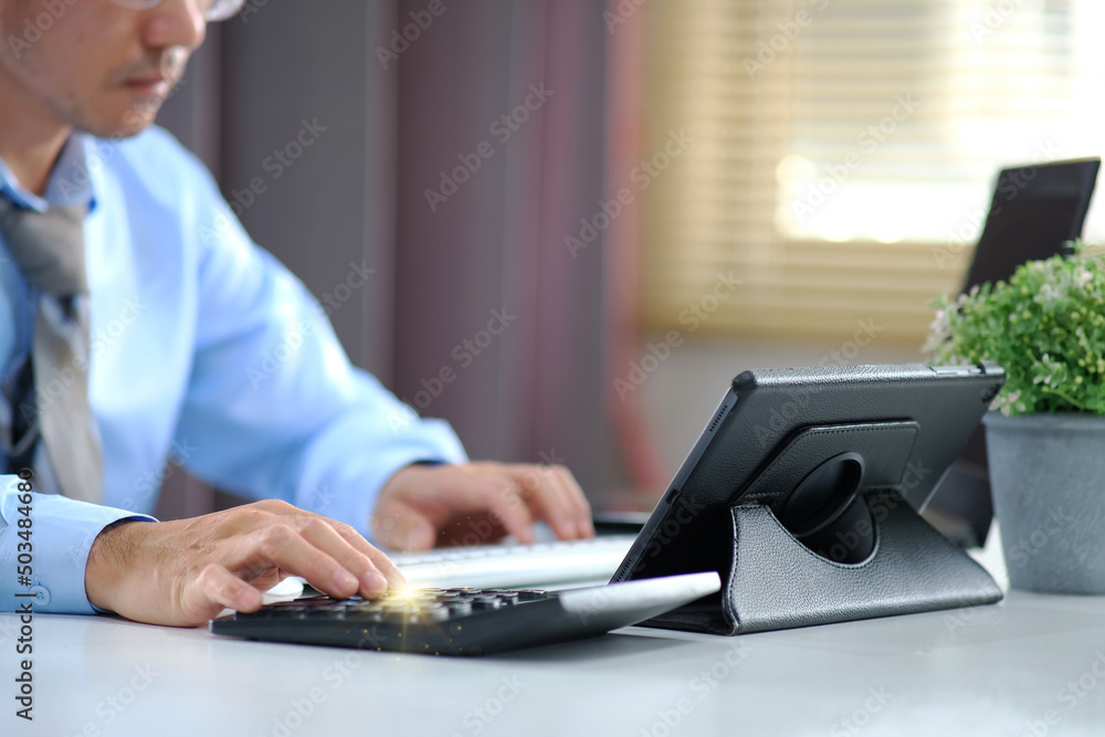 Poster man works by typing on a computer while texting on his cell phone. online learning education for stu