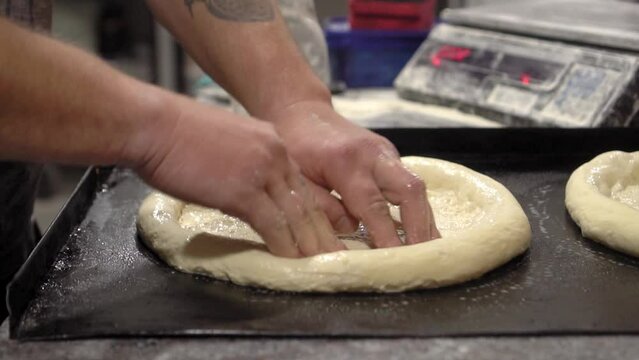 Cooking buns. Rustic style. Process of making bread. kneading dough, cooking buns. Camera movement, panorma of small buns on table. Production of wheat bread. Bakery. Workflow