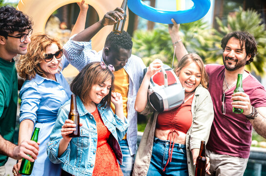 Multicultural friends group having fun out side cheering with boombox and beer bottles - Gen z people enjoying spring break party festival together - Youth life style concept on bright vivid filter