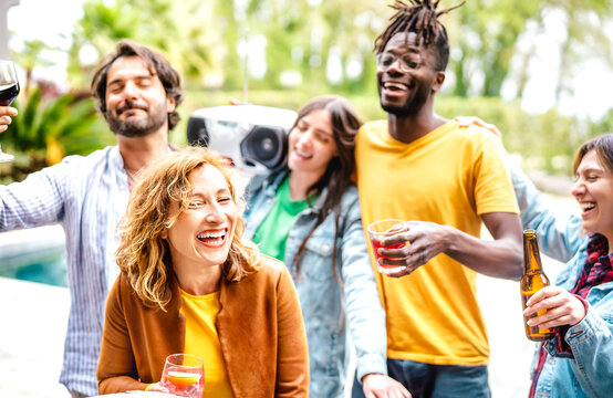 Multiracial friends group having fun out side cheering with boombox and fancy drinks - Gen z people enjoying spring break party festival together - Youth life style concept on bright warm filter
