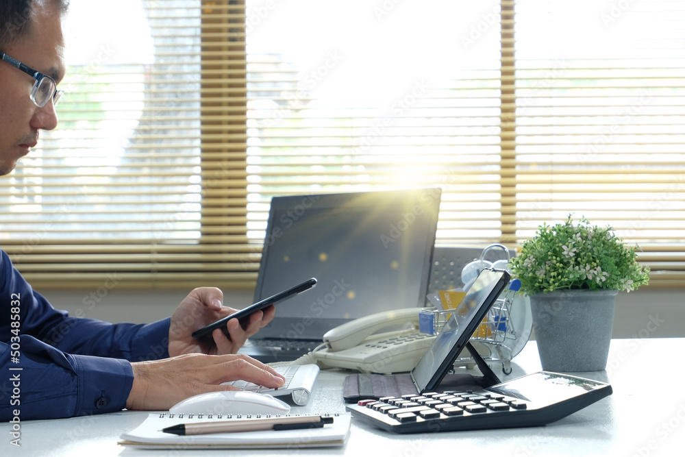 Poster businessman is using his smartphone and laptop. working on a computer or messaging on a smartphone, 