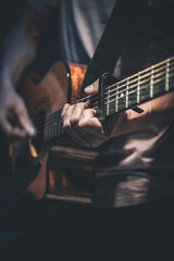 A man plays an acoustic guitar, close-up.