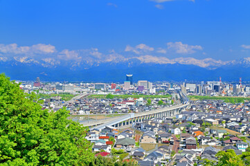 富山市街と立山連峰　呉羽山からの眺め　上下線ですれ違う北陸新幹線