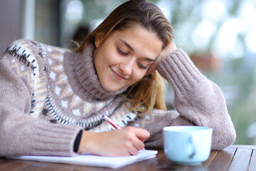 Woman taking notes in a terrace in winter