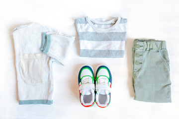 Jumper,t shirt and jeans pants with sneakers. Set of baby children's clothes and accessories for spring, autumn or summer on white background. Fashion kids outfit. Flat lay, top view, overhead