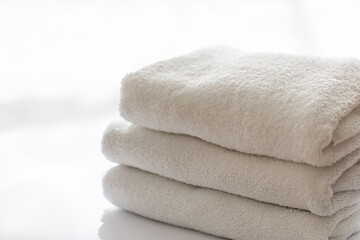 Close up, white terry bath towels stacked, spa concept.