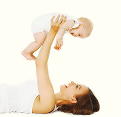 Portrait of happy smiling mother lying on the floor playing with her baby on white background