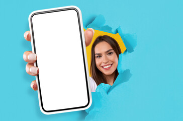 Young lady showing black empty smartphone screen through torn paper