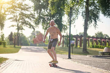 A male skateboarder riding a skateboard and keeping balance