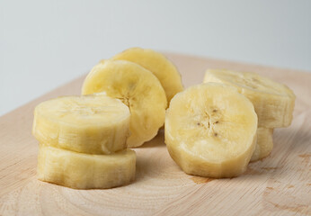 Closeup sliced banana on wood with white background.