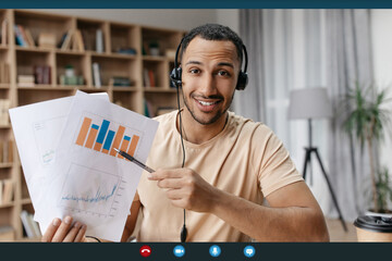 Happy arab businessman making teleconference with colleagues from home, showing reports with graphs and charts
