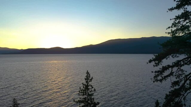 Sun Rising Over Beautiful Mountain Peak, Looking Through Jeffrey Pine Trees on Beautiful Lake Tahoe in the Seara Nevado Mountains California - aerial