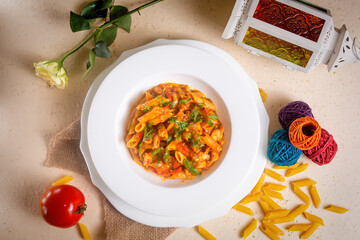 Spicy Penne Masala pasta withraw tomato in a bowl isolated on background side view