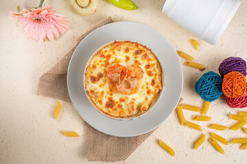 Seefood pasta with cream sauce and raw tomato in a bowl isolated on background side view