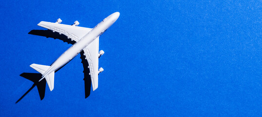 Naklejka na ściany i meble A miniature airplane isolated on blue background, Travel or traffic background, Nobody
