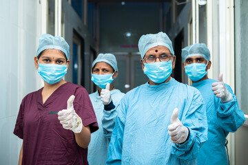 group of surgeons showing thumbs up sign while stadning at hosiptal corridor - approved, successful...