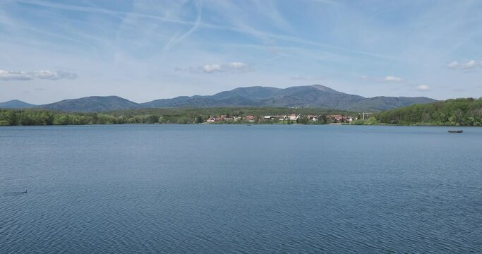 Les eaux calmes du lac et barrage de Michelbach et son village alsacien avec en arriere plan les sommet vosgiens du Rossberg, Waldmatt, Kurrenbourg, Markstein, Croix du Staufen au Grand Ballon 