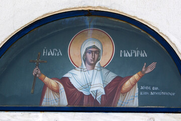Colourful Hagiography of Agia Marina on the facade above the entrance of the chapel with the same name in Porto Rafti area in Greece