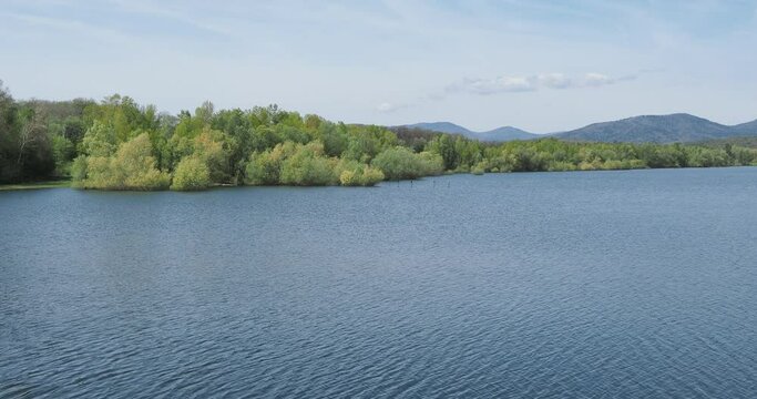 Les eaux calmes du lac de Michelbach dans le Haut-rhin en Alsace. Vue sur la retenue principale et la r&eacute;serve naturelle depuis le parement amont de la digue principale en amont