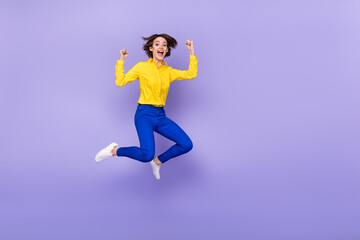 Fototapeta na wymiar Full length photo of sweet millennial brunette lady jump yell wear shirt pants footwear isolated on purple background