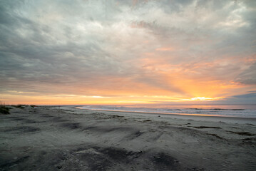 Fototapeta na wymiar Colorful orange dawn sky, beach, sunrise, ocean, waves, Hunting Island, South Carolina coast