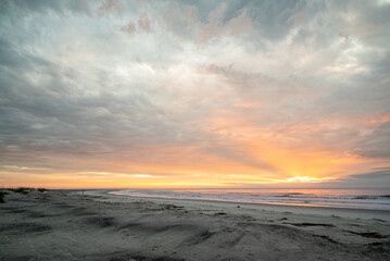 Fototapeta na wymiar Colorful orange dawn sky, beach, sunrise, ocean, waves, Hunting Island, South Carolina coast