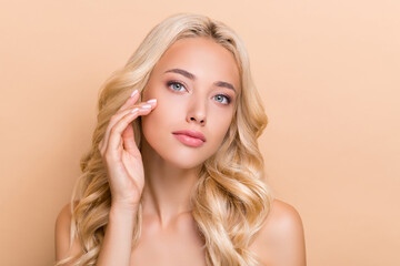 Portrait of attractive confident groomed wavy-haired girl touching soft skin anti acne pore...