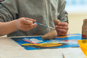 a child makes clay crafts with his hands