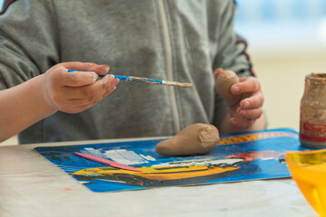 a child makes clay crafts with his hands