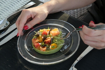 Woman having guacamole with salmon in the restaurant