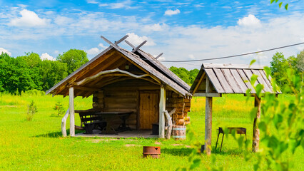 Imitation of a Ukrainian farm. A recreation center in the style of a farmstead with a pond, houses, a bridge, a mill and lotuses in the distance. Taken in July on a sunny day. 