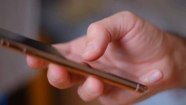 Male hand swiping up on a smart phone. Unrecognizable young man using a swipe gesture in a mobile app on a cellphone