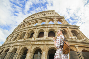  Happy woman tourist looking up at Colosseum. Rome. Italy trip.