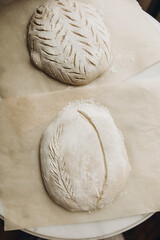 bread dough sprinkled with flour on top. baking craft bread. cut out patterns on bread dough. craft bread close-up.	
