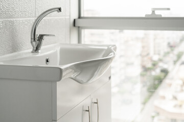Sink with a nightstand in the bathroom with a panoramic window.