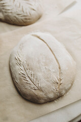 bread dough sprinkled with flour on top. baking craft bread. cut out patterns on bread dough. craft bread close-up. 