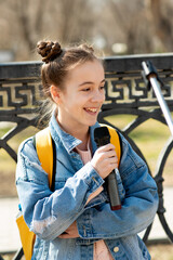 A cute teenage girl with a microphone performs outside. Lifestile. City.