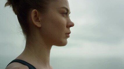 Beautiful girl doing breathing exercise outdoors. Sportswoman meditating yoga.