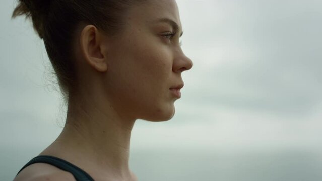 Beautiful girl doing breathing exercise outdoors. Sportswoman meditating yoga.