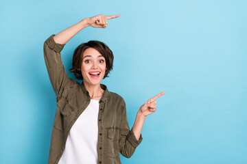 Photo of impressed young brunette lady indicate promotion wear shirt isolated on blue color...