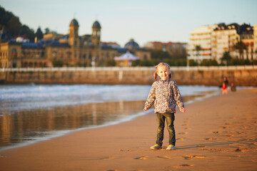 Fototapeta premium Happy little girl on La Concha beach in San Sebastian, Basque Country, Spain