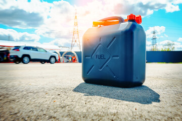Fuel can is on the ground near a gas station. Fuel reserve in jerrycan. Lack of petrol or diesel at gas stations concept.