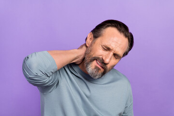 Obraz premium Photo of unsatisfied suffering adult man closed eyes hand touch neck isolated on purple color background