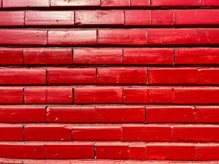 Vibrant red painted brick wall on bright sunshine  close up shot for background.