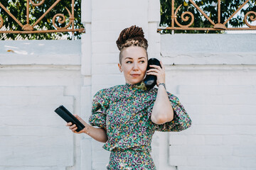 Creator, creative director, artist, producer. Creative portrait of trendy hipster confident woman with dreadlocks holding vegetables eggplant instead of phone