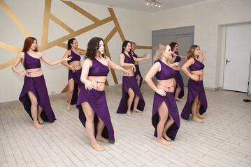 Fototapeta na wymiar A group of beautiful girls in a choreography studio for training dancing in oriental outfits