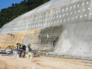 SELANGOR, MALAYSIA -MARCH 4: Construction workers are spraying liquid concrete onto the slope...